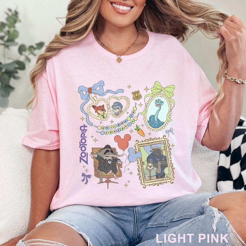 Puede incluir: Camiseta rosa claro con un dise&ntilde;o gr&aacute;fico colorido con personajes y elementos de la pel&iacute;cula animada "Zootopia". El dise&ntilde;o incluye retratos enmarcados, lazos y la palabra "Zootopia" en una fuente estilizada. La camiseta es de material suave.
