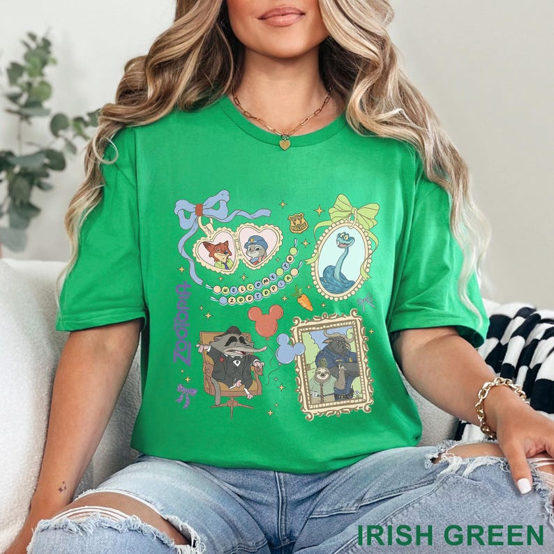 Puede incluir: Camiseta verde irland&eacute;s con personajes de dibujos animados enmarcados y el texto "Zootopia". El dise&ntilde;o incluye un marco en forma de coraz&oacute;n con dos personajes, una insignia, una caricatura de una criatura marina y otros dos personajes enmarcados.