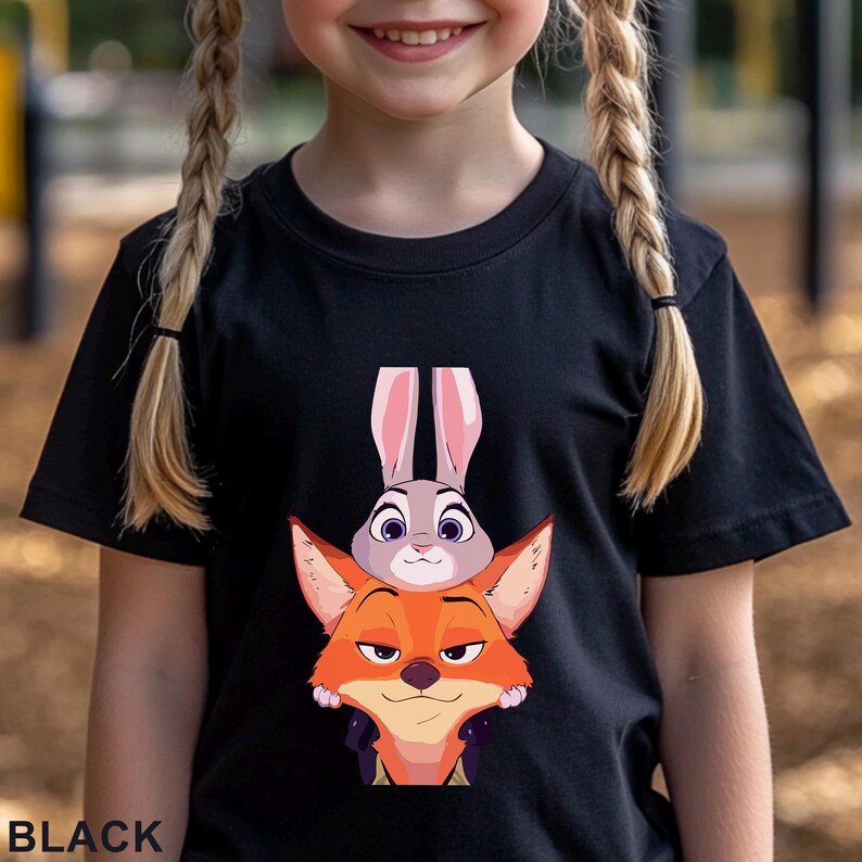 May include: Black t-shirt featuring a cartoon image of Judy Hopps the bunny and Nick Wilde the fox from Zootopia. The word "BLACK" is printed at the bottom of the shirt.