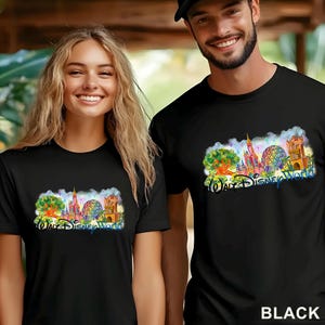 May include: A black t-shirt featuring a colorful watercolor-style graphic of Walt Disney World landmarks, including the Tree of Life, Cinderella Castle, Spaceship Earth, and the Tower of Terror, with the text Walt Disney World printed below.