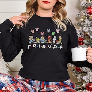 May include: Black sweatshirt featuring cartoon characters and the word "FRIENDS" in white. Above the characters are Mickey Mouse head shapes in various colors. The word "BLACK" is printed at the bottom.