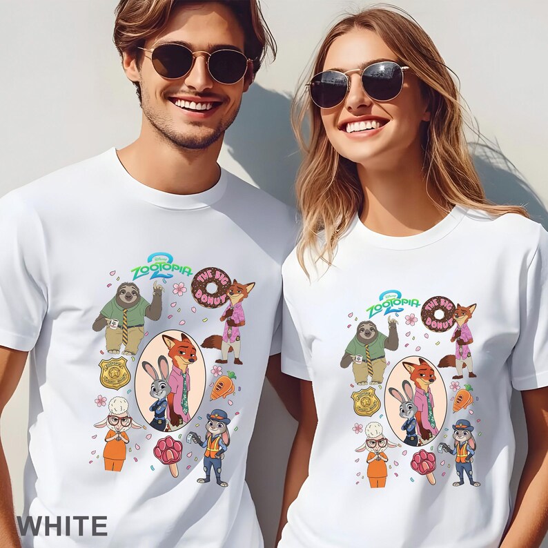 K&ouml;nnte beinhalten: Zwei wei&szlig;e T-Shirts mit Rundhalsausschnitt und einem Zootopia 2 Grafikdruck. Das Design zeigt Charaktere wie Judy Hopps, Nick Wilde und Flash sowie Symbole wie einen Donut, eine Karotte, ein Abzeichen und ein pfotenf&ouml;rmiges Eis am Stiel.
