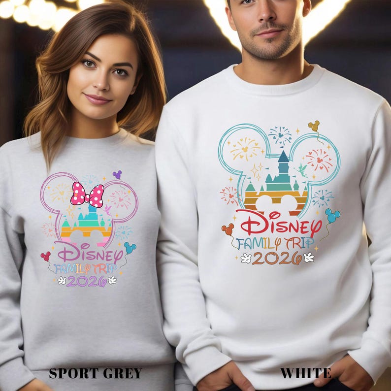 May include: Sport grey and white sweatshirts with Disney Family Trip 2020 designs. The designs feature Mickey Mouse ears, a castle, fireworks, and the Disney logo. The sport grey sweatshirt has a Minnie Mouse bow.