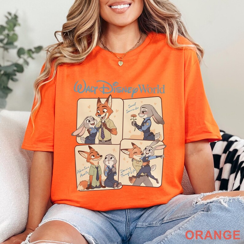 K&ouml;nnte beinhalten: Leuchtend orangefarbenes T-Shirt mit einer Grafik mit vier Panels von Zootopia-Charakteren. Auf dem oberen Panel steht "Walt Disney World" in blauer Schrift. Jedes Panel zeigt Nick Wilde und Judy Hopps in verschiedenen Posen. Das Wort "Orange" ist unten aufgedruckt.