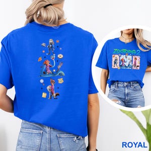 May include: Royal blue t-shirt with a colourful graphic of "Zootopia" characters on the front and back. The back graphic features Judy Hopps, Nick Wilde, and other characters. The front graphic says "Zootopia 2".