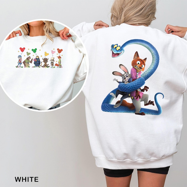 May include: A white long-sleeve sweatshirt featuring a large graphic on the back of a blue snake coiled around a fox and a rabbit. The front chest area displays a smaller graphic of several animated characters holding colorful Mickey-shaped balloons.