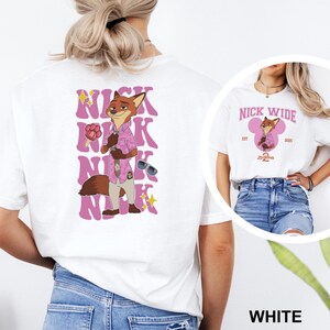 May include: White t-shirt featuring a cartoon fox character in a pink shirt and sunglasses, with the name "Nick" in pink bubble letters. The design includes the text "Nick Wide" and the year "2025".