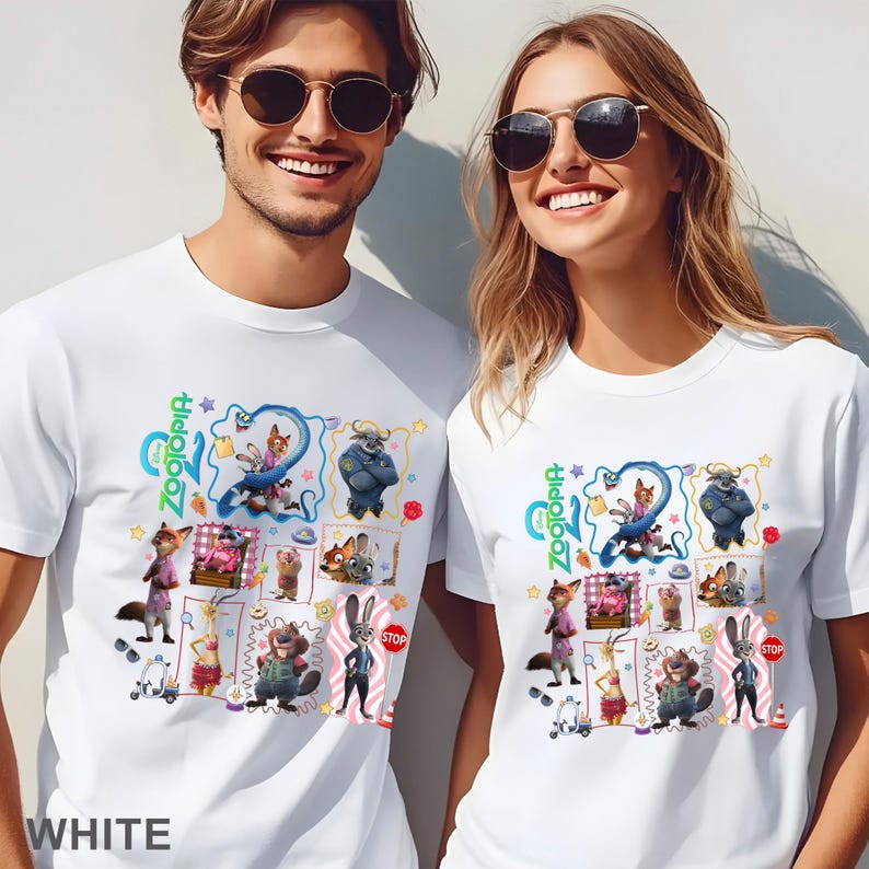 May include: White t-shirts featuring a colorful graphic design from the animated movie Zootopia. The design includes various characters and the movie's logo. The shirts are worn by two people, one male and one female.