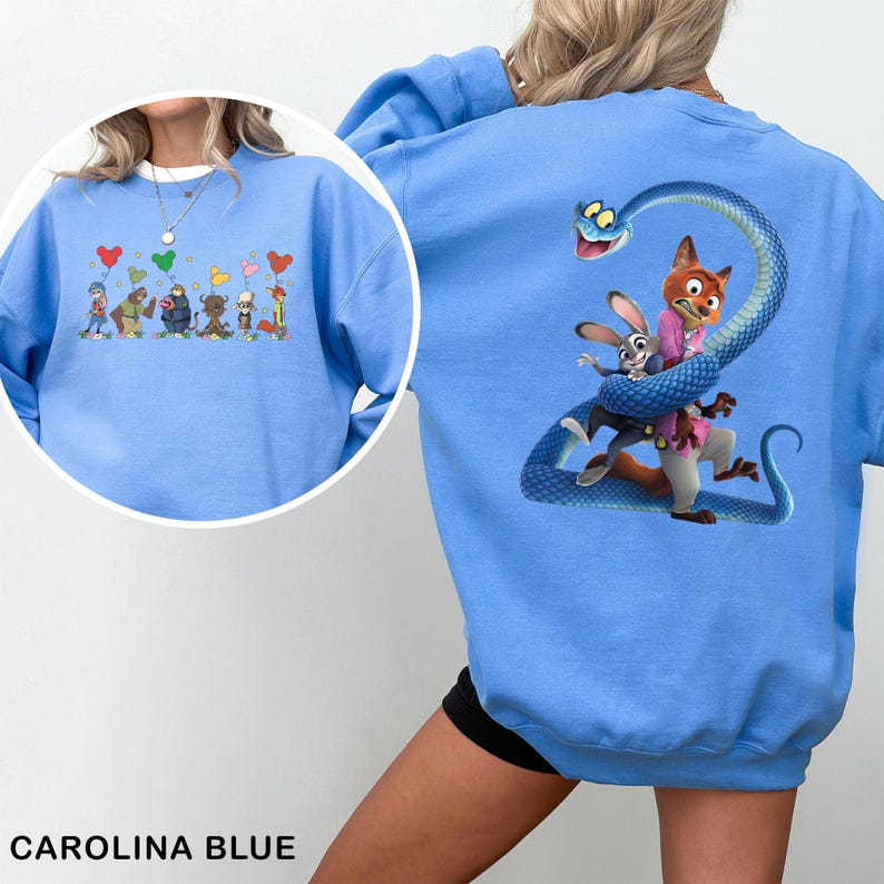 May include: A Carolina blue crewneck sweatshirt featuring a large graphic on the back of a blue snake coiled around a fox and a rabbit. The front chest area displays a smaller graphic of six animated characters holding colorful heart-shaped balloons.