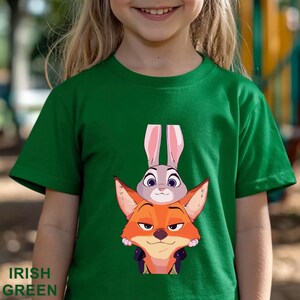 May include: Irish green t-shirt featuring a cartoon image of a fox and a rabbit. The fox is orange and the rabbit is gray with pink ears. The words "IRISH GREEN" are printed at the bottom of the shirt.