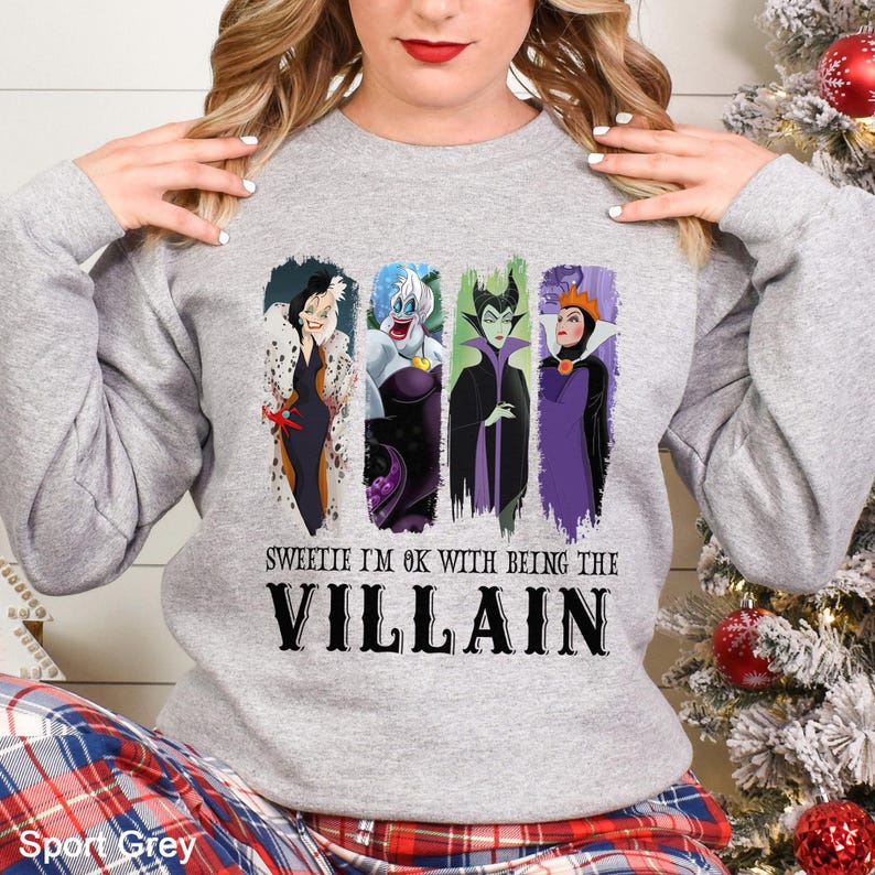 Puede incluir: Sudadera gris deportiva con cuatro ilustraciones de villanos de Disney. El texto "Sweetie I'm ok with being the Villain" est&aacute; impreso debajo de las im&aacute;genes. Cuello redondo y mangas largas.