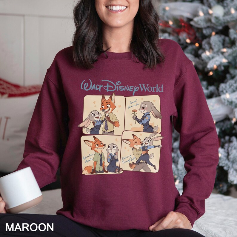 May include: Maroon sweatshirt featuring a four-panel graphic of Zootopia characters. The top panel displays Nick Wilde and Judy Hopps, with the text "Walt Disney World" above. The bottom panel has the word "MAROON" at the bottom.