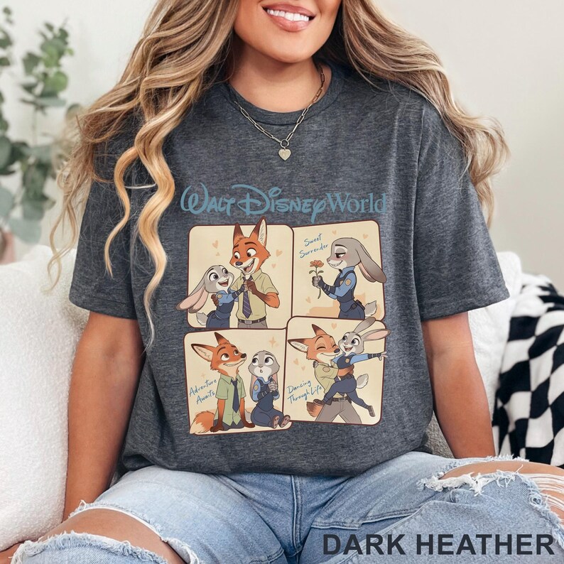 K&ouml;nnte beinhalten: Dunkelgraues meliertes T-Shirt mit einem Cartoon-Design mit Charakteren aus Zootopia. Das Design umfasst vier Panels mit Nick Wilde und Judy Hopps, mit dem Text "Walt Disney World". Das Shirt hat auch den Text "Dark Heather".