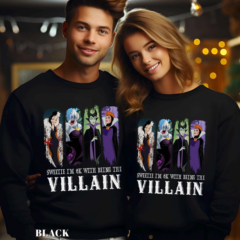 Puede incluir: Sudaderas negras con un gr&aacute;fico de villanos de Disney: Cruella de Vil, &Uacute;rsula, Mal&eacute;fica y la Reina Malvada. El texto "Sweetie I'm ok with being the Villain" est&aacute; impreso debajo de los personajes. La palabra "Black" est&aacute; impresa en la parte inferior.