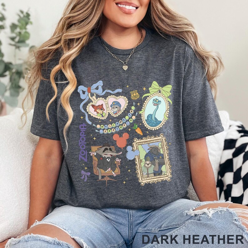 Puede incluir: Camiseta gris jaspeado oscuro con personajes de Zootopia en ilustraciones enmarcadas. La camiseta incluye im&aacute;genes de Nick Wilde, Judy Hopps y otros personajes. El texto "Zootopia" est&aacute; impreso verticalmente en el lado izquierdo. Las palabras "Dark Heather" est&aacute;n impresas en la parte inferior.