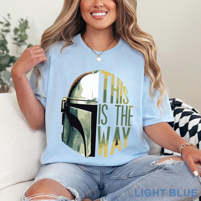 Pu&ograve; includere: Una t-shirt a maniche corte color azzurro con una grafica di un casco metallico sul lato sinistro e il testo THIS IS THE WAY in lettere maiuscole gialle e verdi sul lato destro. La maglietta presenta un girocollo e una vestibilit&agrave; comoda.
