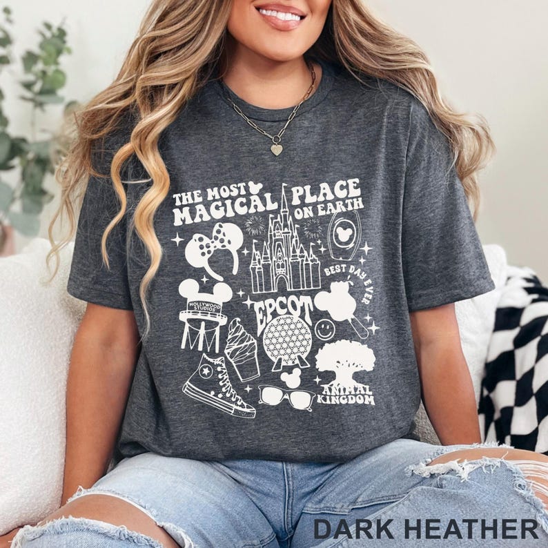 May include: Dark heather gray t-shirt with a white graphic design featuring the text "THE MOST MAGICAL PLACE ON EARTH" and various Disney-themed icons, including a castle, Mickey Mouse ears, and a sneaker. The text "EPCOT" and "ANIMAL KINGDOM" are also included.