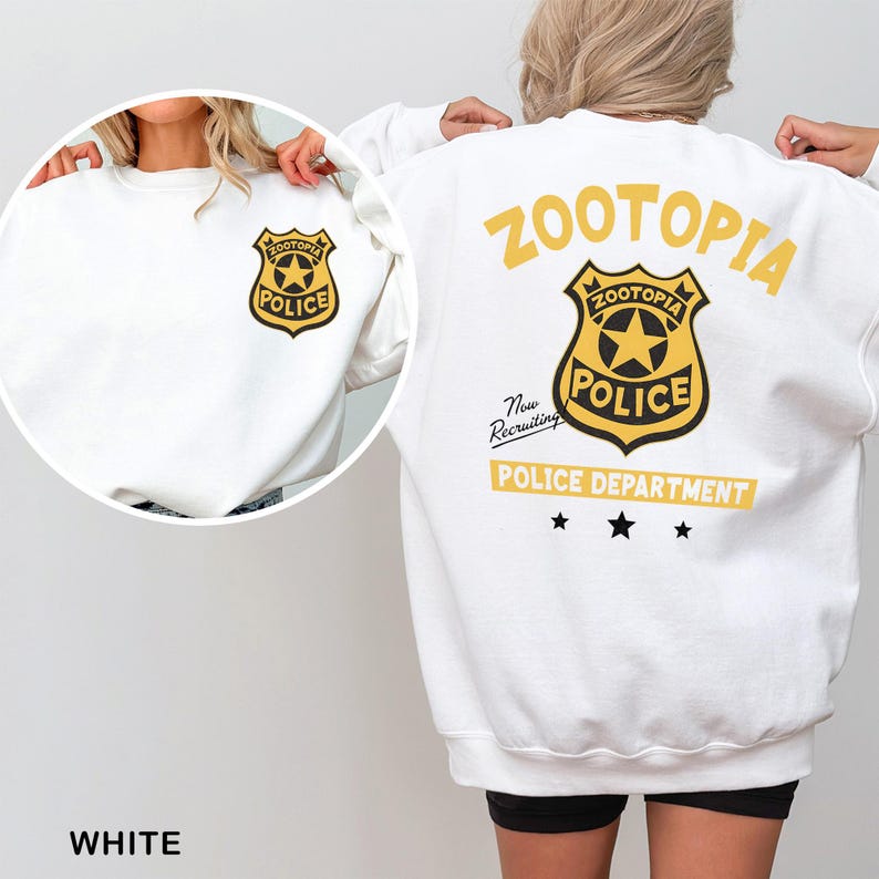 May include: White sweatshirt featuring a gold and black "Zootopia Police" badge on the front and back. The back design includes the word "Zootopia", the badge, "Police Department", and three black stars. The text "Now Recruiting" is also present.
