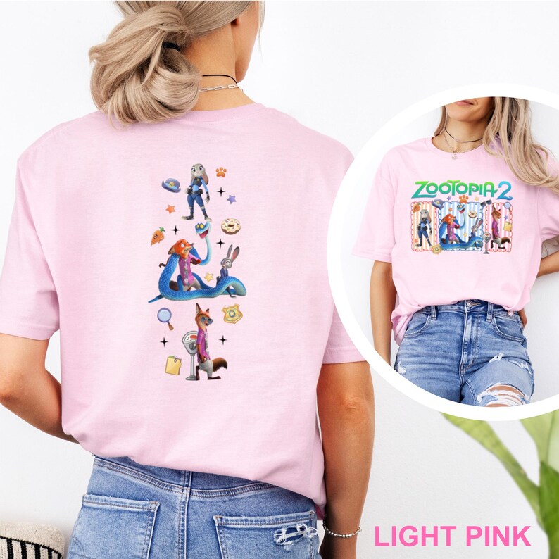 May include: Pale pink t-shirt with characters from Zootopia 2. The front displays the text "ZOOTOPIA 2" above a graphic of the characters. The back has a vertical design with various characters and icons.
