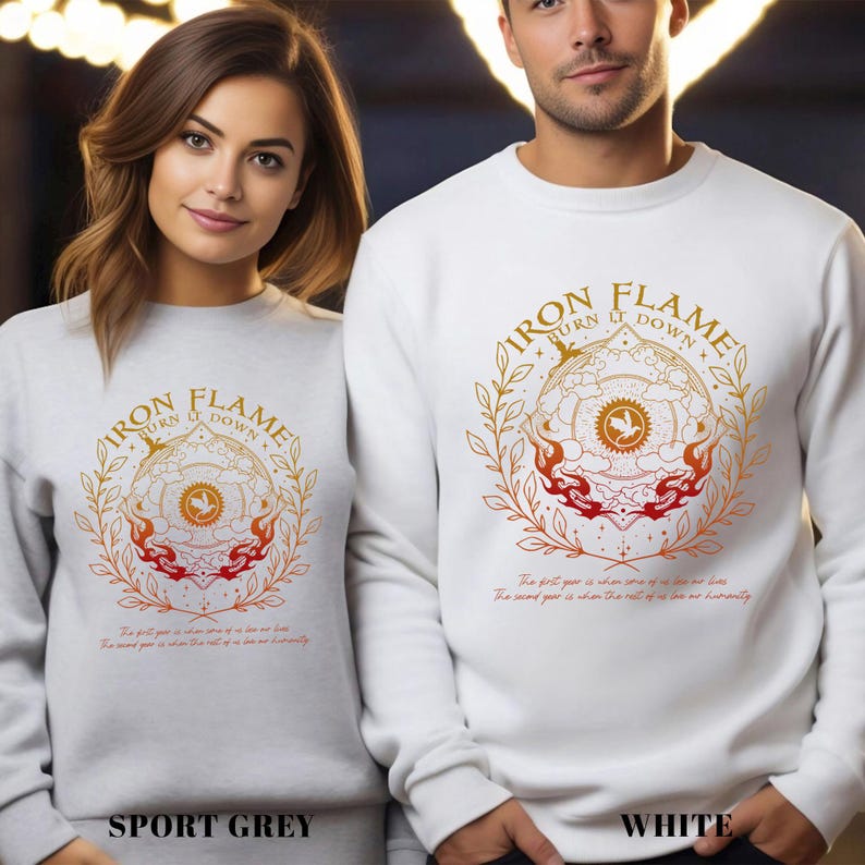 May include: Sport grey and white sweatshirts with a circular graphic design featuring the text "IRON FLAME BURN IT DOWN". The design includes a central emblem with a phoenix and flames, surrounded by a laurel wreath.