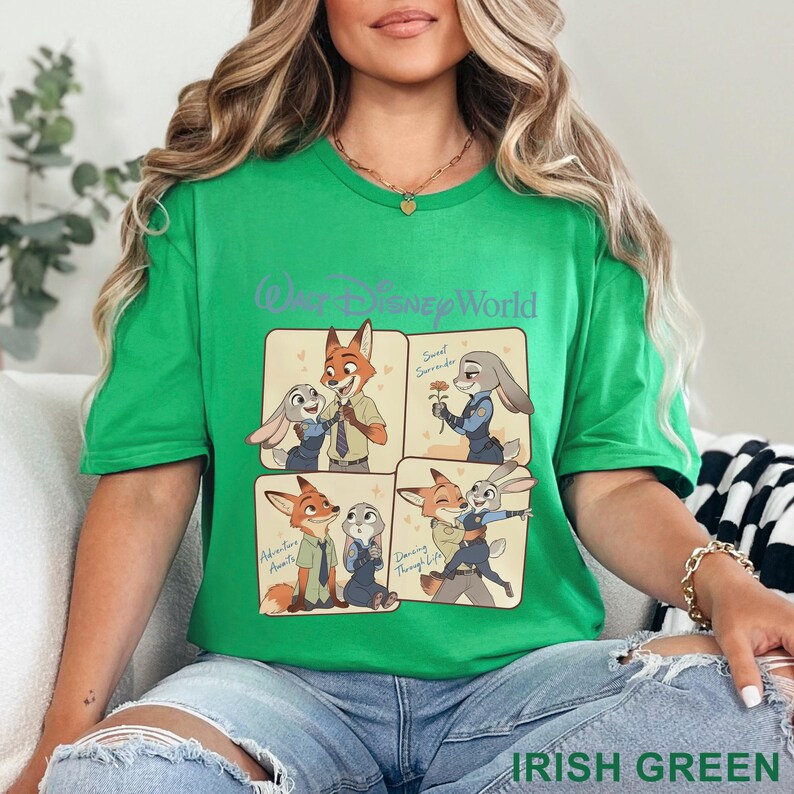 K&ouml;nnte beinhalten: Irisch gr&uuml;nes T-Shirt mit einer Grafik von Nick Wilde und Judy Hopps aus Zootopia, mit den Worten "Walt Disney World" oben. Die Grafik enth&auml;lt vier Panels mit den Charakteren in verschiedenen Posen. Die Worte "Adventure Awaits", "Sweet Surrender" und "Dancing Through Life" sind ebenfalls enthalten.