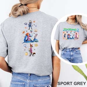 May include: Sport grey t-shirt with a colourful graphic of Zootopia characters. The back displays a vertical design with characters and icons. The front of the shirt features the text "ZOOTOPIA 2".