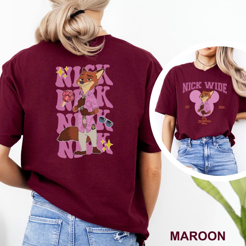 May include: Maroon t-shirt featuring a cartoon fox character with the text "NICK" repeated in a retro style. The fox is wearing a pink shirt and sunglasses. The shirt also has the text "NICK WIDE" and the year "2025".