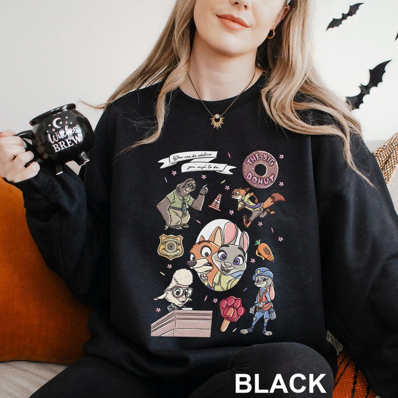 May include: Black sweatshirt featuring colorful cartoon characters and the text "You can be whatever you wish to be." The design includes a donut, a police badge, and various animal characters. The word "BLACK" is printed at the bottom.