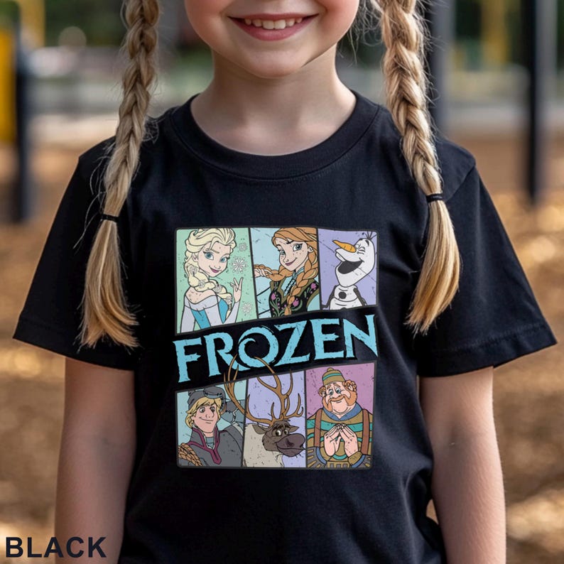 May include: Black t-shirt featuring a colorful graphic of characters from the movie "Frozen." The design includes Elsa, Anna, Olaf, Kristoff, Sven, and a man in a hat. The word "FROZEN" is printed in large, light blue letters. The word "BLACK" is printed at the bottom.