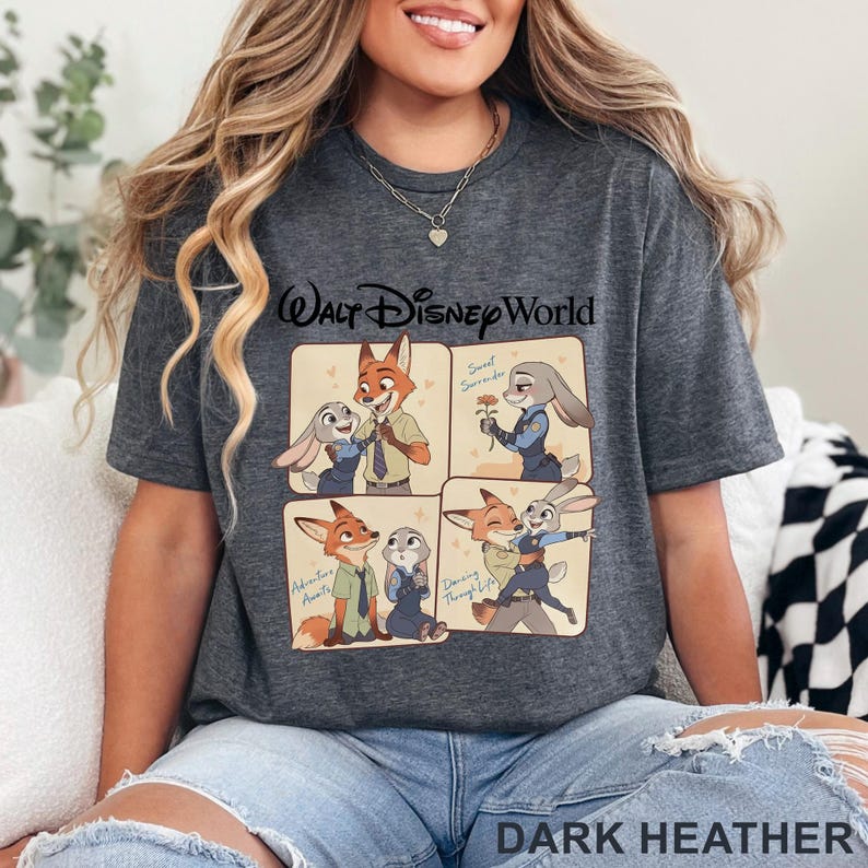 May include: Dark heather gray t-shirt featuring a cartoon graphic of Nick Wilde and Judy Hopps from Zootopia. The graphic includes the text "Walt Disney World" and four panels with different scenes of the characters. The text "Dark Heather" is at the bottom.