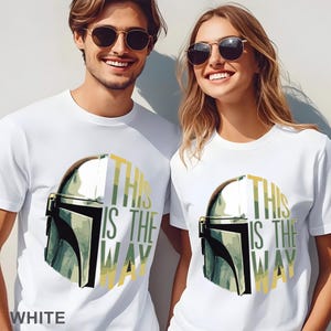 Pu&ograve; includere: Due magliette bianche con una grafica di un casco metallico e il testo "THIS IS THE WAY" in giallo e verde. Il design &egrave; centrato sul petto di ogni maglietta. Le magliette sono a maniche corte con scollo rotondo e una finitura bianca liscia.