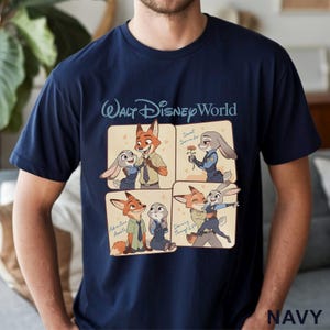 May include: Navy blue t-shirt featuring a cartoon graphic of Nick Wilde and Judy Hopps from Zootopia. The shirt has the text "Walt Disney World" at the top and the word "NAVY" at the bottom.
