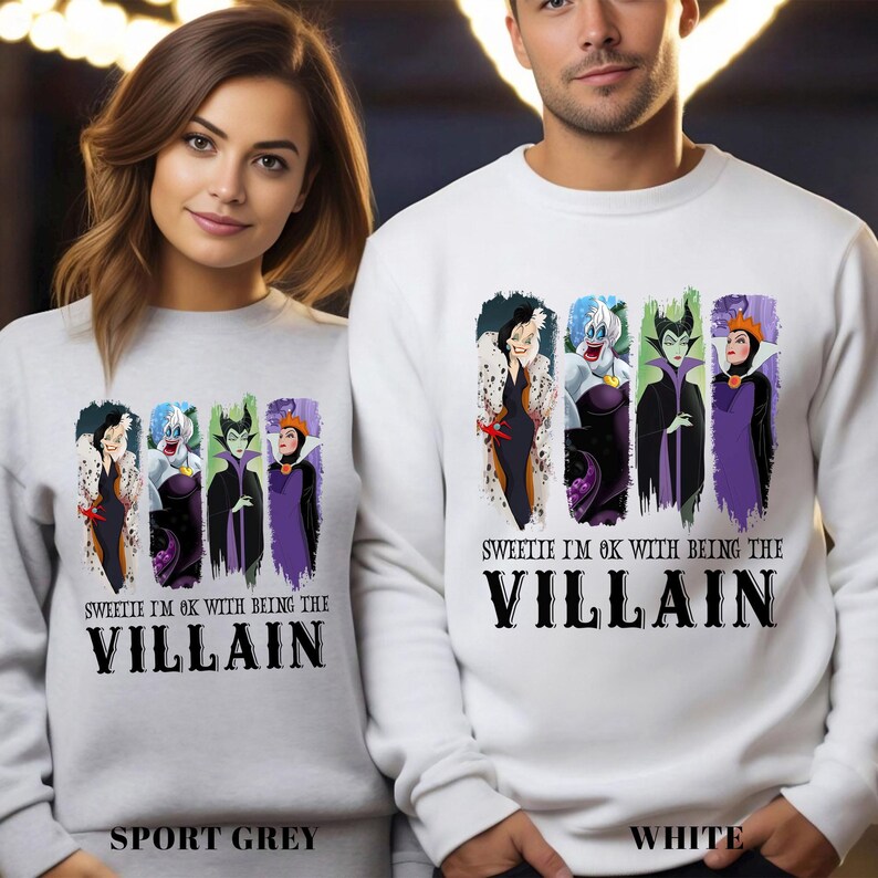 Puede incluir: Sudaderas deportivas grises y blancas con un gr&aacute;fico de cuatro villanos de dibujos animados. El texto "SWEETIE I'M OK WITH BEING THE VILLAIN" est&aacute; impreso debajo de los personajes. Las sudaderas se muestran en una persona.