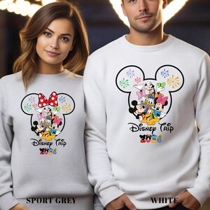 May include: Sport grey and white sweatshirts featuring a Mickey Mouse head design with Disney characters. The sweatshirts have the text "Disney Trip 2020" in colorful letters. The sport grey sweatshirt has a red polka dot bow.