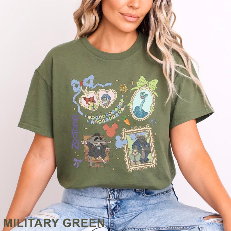 Puede incluir: Camiseta verde militar con ilustraciones enmarcadas de personajes de Zootopia. Las ilustraciones incluyen a Nick Wilde y Judy Hopps, una criatura parecida al monstruo del lago Ness y Mr. Big. La palabra "Zootopia" est&aacute; impresa verticalmente a la izquierda.