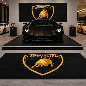 Peut inclure: Une voiture de sport Lamborghini noire est présentée sur une plateforme surélevée. Le logo Lamborghini est mis en évidence sur une toile de fond et un tapis de sol. D'autres véhicules Lamborghini blancs et jaunes sont également visibles.