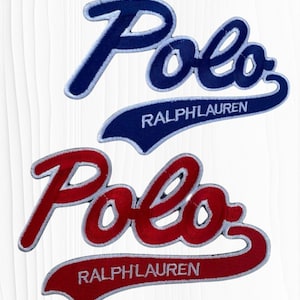 May include: Two embroidered patches featuring the word "Polo" in a script font, with "RALPHLAUREN" underneath. One patch is navy blue with white trim, the other is red with white trim. The patches are likely for clothing or accessories.