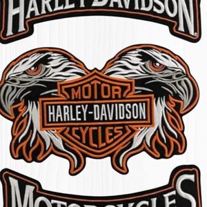 May include: Embroidered Harley-Davidson patches featuring the brand name and eagle designs. The patches are black, white, and orange. The text includes "HARLEY-DAVIDSON", "MOTOR CYCLES", and "MOTOR HARLEY-DAVIDSON CYCLES".