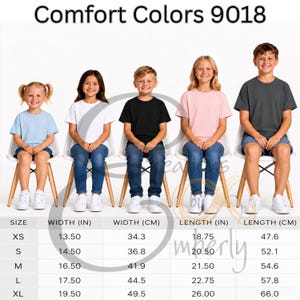 以下が含まれることがあります： Comfort Colors 9018 Tシャツのサイズ表。水色、白、黒、ピンク、ダークグレーのTシャツを着た5人の子供が並んでいます。下の表には、幅と長さがセンチメートル単位で記載されています。