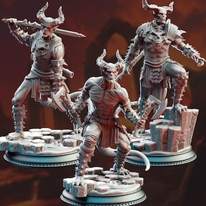 Könnte beinhalten: Drei detaillierte Fantasy-Figuren von gehörnten Dämonen. Jede Figur posiert auf einem felsigen Sockel, mit aufwendiger Rüstung und Waffen, darunter Schwerter und Äxte. Die Figuren haben ein skelettartiges Aussehen mit Hörnern und Schwänzen und sind in Grautönen bemalt.