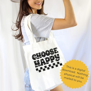 K&ouml;nnte beinhalten: Wei&szlig;e Einkaufstasche mit schwarzem Text, der "CHOOSE HAPPY" in einer Retro-Schriftart lautet. Der Text ist von kleinen Herzen und einem karierten Muster umgeben.