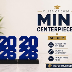 May include: Two blue "2026" mini centerpieces on black bases. The text "CLASS OF 2026" and "MINI CENTERPIECES" are displayed above the centerpieces. The image also includes the text "SET OF 2" and "MATCH YOUR COLORS".