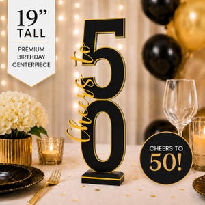 May include: A 19-inch tall black and gold birthday centerpiece featuring the number 50 and the text Cheers to 50. The design includes a vertical black number 50 with gold trim and the script text Cheers to in gold on the side of the number.