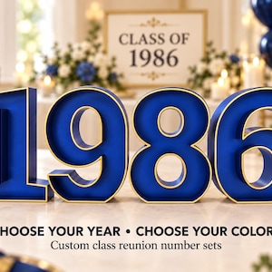 May include: Large, three-dimensional numbers forming 1986 in a deep blue finish with gold-toned edges. The text below reads: CHOOSE YOUR YEAR • CHOOSE YOUR COLORS. Custom class reunion number sets. These freestanding numbers are displayed on a table.