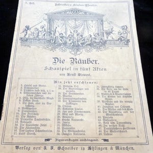 Könnte beinhalten: Ein Vintage-Theaterprogramm mit dem Titel "Die Räuber". Das Programm zeigt eine detaillierte Illustration einer Bühne mit Schauspielern und Text auf Deutsch. Das Programm listet weitere Theaterstücke auf.