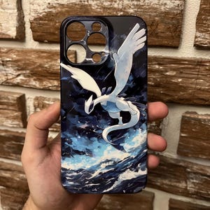 May include: A black phone case with a white and blue illustration of a mythical winged creature, set against a stormy sea and dark sky. The case has cutouts for the phone's camera and buttons.