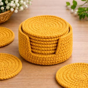 May include: A set of mustard yellow crochet coasters and a matching holder. The coasters are round, with a spiral pattern, and are approximately 4 inches in diameter. The holder is cylindrical with a cutout for easy access.
