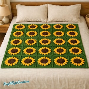 Może przedstawiać: Ręcznie robiony koc szydełkowy z powtarzającym się wzorem słoneczników. Koc ma zielone tło z żółtymi i brązowymi słonecznikami. Koc jest prezentowany na łóżku z białymi prześcieradłami i poduszkami.
