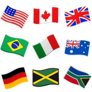 Puede incluir: Una colección de nueve adornos con forma de bandera. Las banderas incluyen las de Estados Unidos, Canadá, Reino Unido, Brasil, Italia, Australia, Alemania, Jamaica y Sudáfrica. Cada bandera tiene una forma y un diseño únicos.