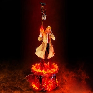May include: A detailed figurine of a character in a tan trench coat, red tie, and black pants, holding a flaming torch. The figure stands atop a fiery base with a decorative lamp post and a raven. The background is a dark red.